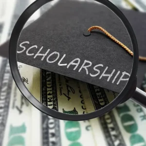 Hình ảnh chiếc kính lúp phóng to chữ Scholarship trên mũ cử nhân với phông nền tiền giấy, minh họa cho hành trình tìm kiếm học bổng du học Thụy Sĩ.